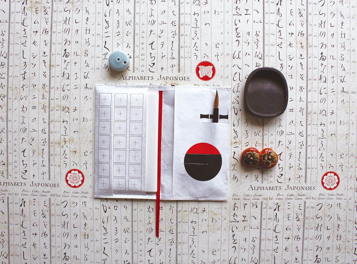 中を開いて、右側のスリット部分には筆置きと硯のイメージが。左側には懐紙に文字を書く時に下敷きにできるよう、ます目を施しました。